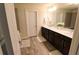 Bathroom with a double sink vanity, framed mirror, and wood-look floors at 3262 Hanging Tide St, Winter Garden, FL 34787