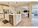 Open-concept living area featuring a modern kitchen island, wood-look flooring, and a comfortable seating area at 3262 Hanging Tide St, Winter Garden, FL 34787