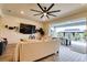 Bright living room featuring a ceiling fan, large screen television, and an open design to the outdoor patio area at 3262 Hanging Tide St, Winter Garden, FL 34787