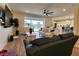 Open-concept living room flows to lanai and kitchen, featuring modern furnishings and a ceiling fan at 3262 Hanging Tide St, Winter Garden, FL 34787