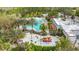 An aerial view shows a large community pool, splash area, and clubhouse with vibrant greenery at 426 Captiva Dr, Davenport, FL 33896