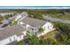 An aerial view of townhouses with lush surroundings, including a serene pond and mature trees at 426 Captiva Dr, Davenport, FL 33896