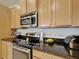 Modern kitchen features stainless steel appliances, and wooden cabinets for ample storage at 426 Captiva Dr, Davenport, FL 33896
