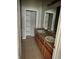 Bathroom showcasing double sinks, a walk-in closet with shelving, and tile floors at 4406 Hidden Meadow Dr, Kissimmee, FL 34746