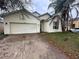 Exterior of one-story home with attached garage, neutral stucco siding, and lawn at 4406 Hidden Meadow Dr, Kissimmee, FL 34746