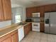 Kitchen with wood cabinets, white appliances, and laminate countertops at 4406 Hidden Meadow Dr, Kissimmee, FL 34746