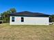 Side view of a single story home with stucco exterior and windows with dark trim, set against a clear blue sky at 4491 Sw 151 St, Ocala, FL 34473