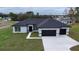A lovely single-story home with a dark roof, black garage door, neutral stucco exterior, and healthy green lawn at 4491 Sw 151 St, Ocala, FL 34473