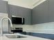 Modern kitchen with stainless steel appliances, sleek grey cabinets, and a quartz countertop at 4491 Sw 151 St, Ocala, FL 34473