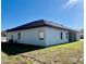 Light stucco home with dark trim, rear covered patio, and an air conditioning unit at 4491 Sw 151 St, Ocala, FL 34473