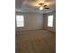 Spacious main bedroom with carpet floors, tray ceiling, and two windows at 4710 Willoughby St, Kissimmee, FL 34758