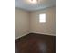 A simple room with hardwood floors and a window provides a bright space at 4710 Willoughby St, Kissimmee, FL 34758