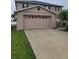 Exterior view of the two-car garage with a long concrete driveway and well-manicured lawn at 4710 Willoughby St, Kissimmee, FL 34758