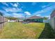 Spacious backyard with green grass, pool with safety fence, and covered patio at 4740 Cypress Forest Ln, St Cloud, FL 34772