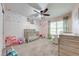 Charming Bedroom featuring soft pink walls, neutral carpet, and a decorative floral accent wall at 4740 Cypress Forest Ln, St Cloud, FL 34772