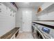 Well-equipped laundry room with modern washer and dryer, plus a bench and storage shelves at 4740 Cypress Forest Ln, St Cloud, FL 34772