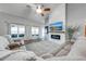 Open-concept living room with a fireplace, hardwood floors, a ceiling fan, and large windows at 4740 Cypress Forest Ln, St Cloud, FL 34772