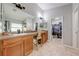 Well-appointed bathroom featuring a double sink vanity, a large mirror, and direct access to a walk-in closet at 4740 Cypress Forest Ln, St Cloud, FL 34772