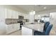 Well-lit kitchen with white cabinetry, island seating, and stainless steel appliances at 486 Disa Dr, Davenport, FL 33837