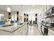 Open kitchen with white cabinets, stainless steel appliances, and breakfast bar flowing into dining area at 486 Disa Dr, Davenport, FL 33837