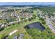 An aerial view of a home near a golf course and pond with lush greenery and a verdant landscape at 514 Cadiz Dr, Davenport, FL 33837