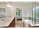 Bright bathroom features a double vanity, soaking tub, and bedroom view at 514 Cadiz Dr, Davenport, FL 33837