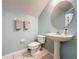 Stylish powder room features pedestal sink, round mirror and neutral color palette at 532 Kildrummy Dr, Davenport, FL 33896