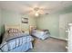 Bright bedroom featuring two twin beds with plaid bedding, a ceiling fan, and light green walls at 532 Kildrummy Dr, Davenport, FL 33896