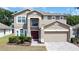 Charming two-story home featuring a brick paver driveway, a two-car garage, and a well-manicured front yard at 532 Kildrummy Dr, Davenport, FL 33896