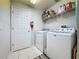 Functional laundry room with washer, dryer, shelving, and tile flooring at 532 Kildrummy Dr, Davenport, FL 33896