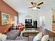 Comfortable living room with hardwood floors, ceiling fan, entertainment area, and natural light at 532 Kildrummy Dr, Davenport, FL 33896