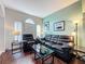Inviting living room with dark wood floors, large windows, and comfortable black leather seating at 532 Kildrummy Dr, Davenport, FL 33896