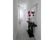 Hallway with gray tile flooring, neutral paint, modern decor, and a textured mirror at 5539 Maddie Dr, Haines City, FL 33844