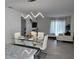 Open-concept living and dining area with modern lighting, elegant furniture, and a view of the entertainment center at 5539 Maddie Dr, Haines City, FL 33844