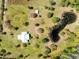 Overhead shot of property showcasing a modern home with a pond, surrounded by mature trees and expansive green space at 5801 N Kenansville Rd, St Cloud, FL 34773