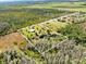 Bird's-eye view outlining property lines and residence with pond surrounded by trees and landscaping and wooded borders at 5801 N Kenansville Rd, St Cloud, FL 34773