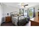 Bedroom featuring wood floors, windows with curtains, and a wrought iron bedframe at 5801 N Kenansville Rd, St Cloud, FL 34773