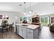 Open-concept kitchen with stainless steel appliances, a large island, and a seamless view into the living room at 5801 N Kenansville Rd, St Cloud, FL 34773