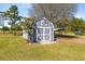 Charming outbuilding with double doors and decorative accents, set in a lush lawn, with mature landscaping at 5801 N Kenansville Rd, St Cloud, FL 34773