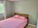 A simple bedroom featuring a comfortable bed with pink bedding and a window providing natural light at 731 Wyman Ct # 731-A, Orlando, FL 32809
