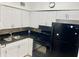 Functional kitchen features white cabinets, a black range, and a refrigerator at 731 Wyman Ct # 731-A, Orlando, FL 32809