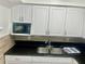 Kitchen featuring white cabinets, granite countertops, and stainless-steel sink at 731 Wyman Ct # 731-A, Orlando, FL 32809