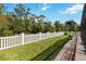 A white picket fence borders the manicured lawn in the backyard, creating a private outdoor space at 784 Seneca Trl, St Cloud, FL 34772