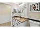 Cozy bathroom with white vanity and cabinets, a framed mirror, and a decorative tiled wall at 784 Seneca Trl, St Cloud, FL 34772