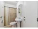 Small bathroom with neutral shower, pedestal sink, toilet, and white medicine cabinet at 784 Seneca Trl, St Cloud, FL 34772