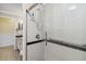 Tiled shower with a glass door and grab bar, adjacent to a bathroom vanity and toilet at 784 Seneca Trl, St Cloud, FL 34772