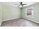 Bedroom features a modern ceiling fan, light green walls, and a window overlooking backyard at 784 Seneca Trl, St Cloud, FL 34772