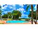 Sparkling community pool with a brick surround, inviting lounge chairs, and views of the lake in the background at 784 Seneca Trl, St Cloud, FL 34772