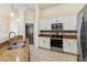 Modern kitchen featuring stainless steel appliances, granite countertops, and white cabinets at 784 Seneca Trl, St Cloud, FL 34772