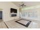 Open living room with fireplace, ceiling fan, tile floor and bright natural light at 784 Seneca Trl, St Cloud, FL 34772
